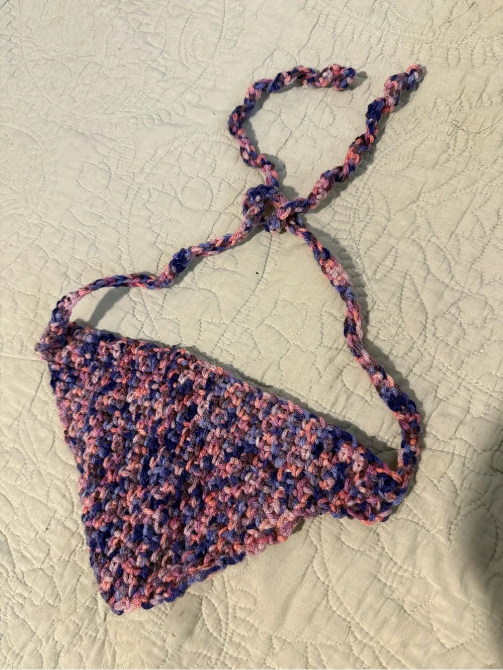 Handmade crochet bandana in pink, blue, and purple marbled yarn.